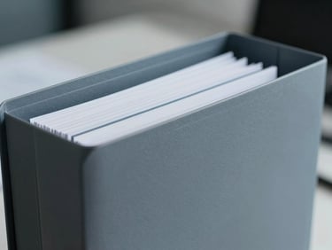 Macro close-up of high-quality business document folders and clean modern corporate stationery, cool office lighting, shallow depth of field.