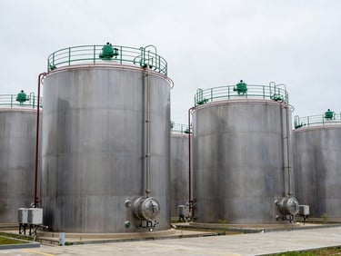 Row of large-scale outdoor industrial chemical storage tanks, stainless steel, overcast clean sky, sharp focus