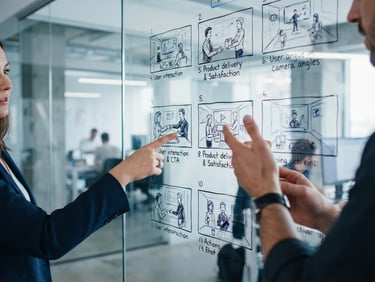 Close-up of a storyboard layout sketched on a glass whiteboard, hands pointing to localized video ad frames, cool-toned studio lighting