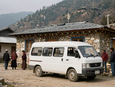 A white mobile medical van parked outside a traditional stone house in a Himalayan village, local residents waiting in soft daylight.