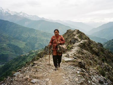 A local midwife walking along a narrow mountain ridge with a medical kit, distant green hills under soft overcast sky, 35mm