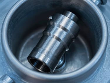 Close-up of a stainless steel jet nozzle inside a large industrial tank, smooth metallic surface, crisp directional studio lighting, metallic steel and safety blue tones, macro lens, high contrast