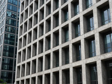 Structured architectural perspective of modern concrete and glass building lines, cool daylight, sharp shadows.