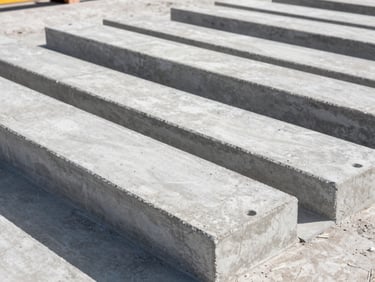 Prefabricated concrete transformer pad on an industrial jobsite under bright daylight, sharp details