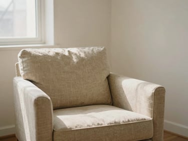 A quiet, warm consulting room with a soft beige linen armchair, gentle window light casting soft shadows, minimalist clinical psychology setting