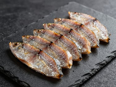 Thinly sliced smoked pike-perch arranged in precise overlapping layers on a dark slate board, studio overhead light, no garnish, texture and colour visible