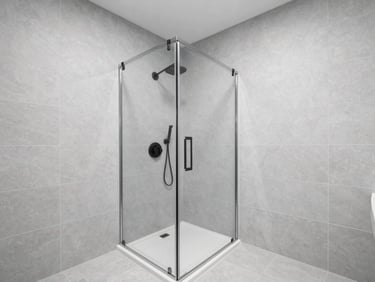 Immaculate luxury bathroom with seamless large-format gray porcelain tiling, a walk-in shower with recessed matte black fixtures, soft natural light.