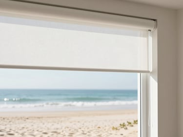 Close-up of a sleek white motorized roller shade operating smoothly in a sun-drenched coastal room.