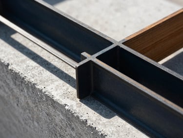 Macro close-up of structural steel embedded in raw architectural concrete, harsh directional sunlight, high contrast, 35mm