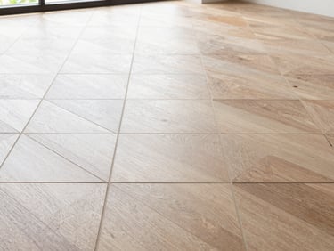 Close-up of geometric pattern tile floor with clean, uniform grout lines, bright natural Florida daylight, straight-on architectural view.
