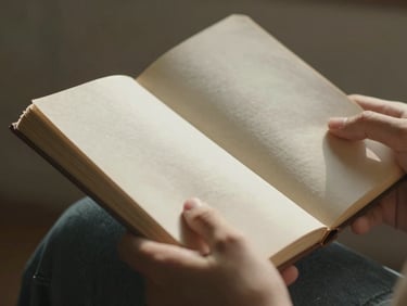 Close-up of hands holding a worn journal, soft morning light, rich textures, shallow depth of field.