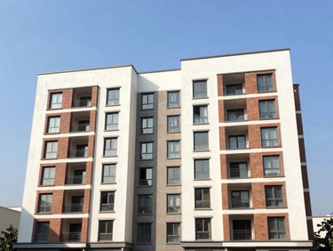 Clean exterior shot of a modern Dwarka cooperative society apartment block with brick accents under clear daylight