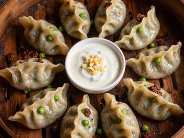 Overhead shot of delicate, hand-folded Mantu dumplings topped with seasoned beef, split peas, and garlic yogurt sauce, warm side-lighting, rich deep tones, 35mm