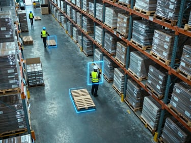 High-angle CCTV perspective of a high-density logistics warehouse, workers in safety gear moving pallets, digital bounding boxes around helmets, cool blue lighting
