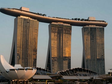 Futuristic glass structures of Marina Bay Sands, Singapore, illuminated by golden-hour ambient glow.