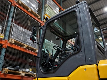 Heavy-duty reach truck cabin view looking up through the safety cage at high warehouse racks