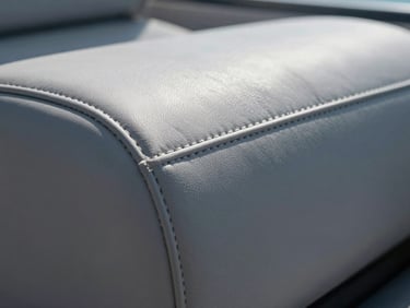 Extreme close-up of marine-grade vinyl seam on a boat seat, double-stitched with UV-resistant thread, strong daylight showing texture and salt-proof weave detail