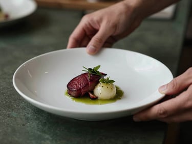 Tight macro shot of hands plating a delicate dish in a moody, warm-toned kitchen, shallow depth of field, 35mm