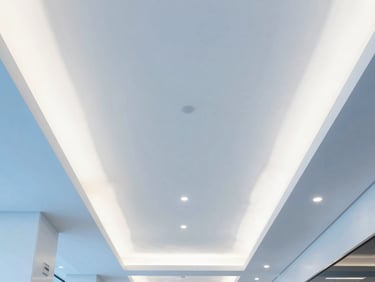 Symmetrical close-up of a modern office lobby ceiling with architectural lighting, clean white and blue tones
