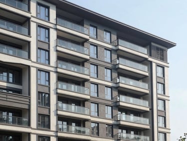 Modern residential building exterior during daylight, clean architectural lines, realistic mid-range apartment facade.