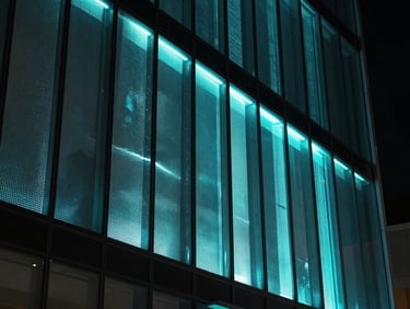 Macro shot of a 3D holographic glass LED film display integrated into a modern glass facade, showing intricate details of the film and a glowing neon cyan projection, low-key ambient lighting, straight-on angle.