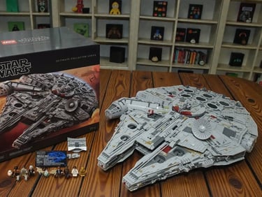 Vue d'ensemble du Faucon Millenium LEGO UCS 75192 avec l'équipage complet des deux trilogies et son emballage imposant.