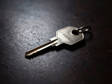 Macro shot of physical key and cryptographic hardware on a dark metal table, single directional key light, deep shadows