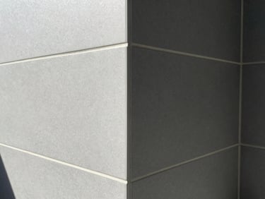 Straight-on shot of modern bathroom tile, highlighting sharp corners, perfect alignment, and clean grout lines, architectural lighting