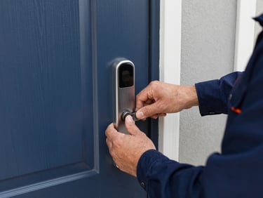 Close-up, bright clear daylight, professional hands in uniform installing a high-quality deadbolt on a residential door, crisp commercial photography