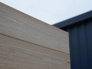 Close-up of cross-laminated timber grain showing clean, uniform glue lines under high-contrast laboratory light