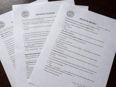 Overhead flat-lay of stamped court foreclosure documents spread across a dark desk, official county seal visible, case numbers legible, even institutional overhead lighting revealing paper texture