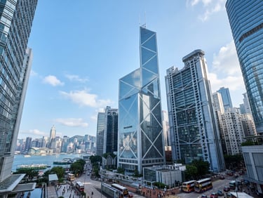 Wide-angle architectural shot of Hong Kong's financial district, sharp lines of glass and steel, cool blue and silver tones, crisp daylight, 35mm lens.