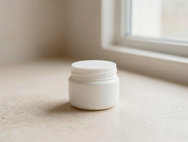 Minimalist white jar of barrier repair cream on a smooth, light beige stone surface, soft morning window light, cream and blush tones, shallow depth of field, 35mm