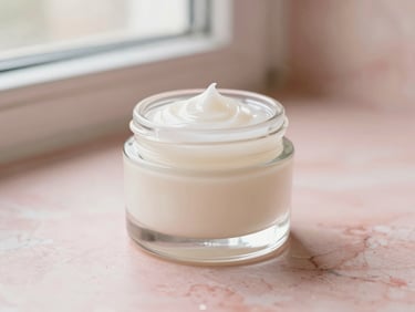 Clear glass jar of lightweight gel moisturizer on a textured pink marble surface, soft morning window light, cream and blush tones, shallow depth of field, 35mm