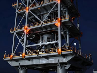 Structural steel frame of a heavy military launch platform, FEA stress deformation model with warm orange highlights on joints, technical blueprint aesthetic