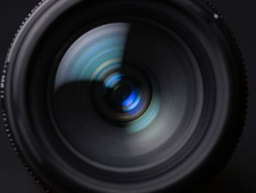 Macro shot of optical glass refracting blue light beams, dark obsidian background, sharp directional light, cool-toned shadows, 35mm lens.