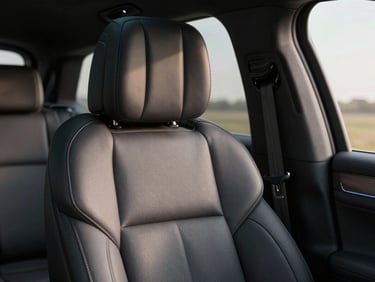 Cinematic close-up of a modern SUV leather seat, soft morning light, executive travel vibe