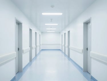 Wide architectural shot of a pristine, brightly lit hospital corridor with cool-toned clinical lighting.