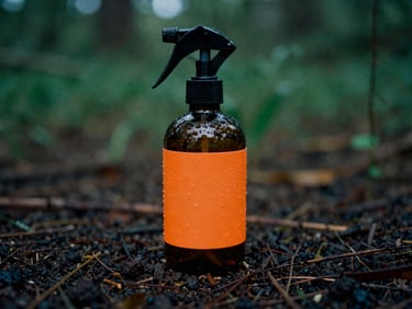 Amber glass spray bottle resting on damp dark soil, safety orange label detail, 35mm film