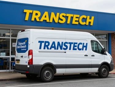 Branded TRANSTECH service vehicle parked outside a local Elizabeth business, clear branding, daylight, street view.
