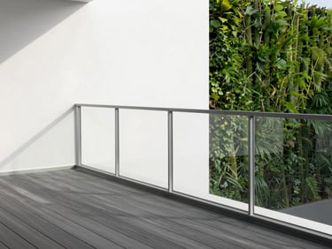 Modern minimalist balcony with composite wood decking, sleek glass railing, vertical green wall, soft afternoon sunlight