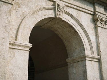A close-up of a weathered stone archway with intricate carvings, soft shadows, film grain