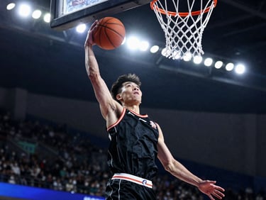 Tight action crop of a young basketball player in mid-air, eyes focused on the rim, dramatic side-lit stadium lights, high contrast athletic tones, action freeze-frame.