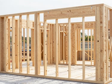 Clean, organized residential construction site, new framing visible, bright natural light, focused on structure
