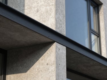 Extreme close-up of a concrete and steel junction on a modern minimalist house, sharp morning sunlight casting dramatic shadows.