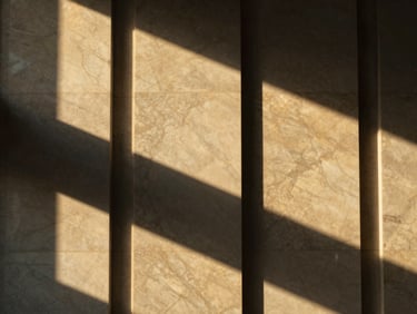 Abstract geometric shadows on a premium marble wall, luxury corporate interior, warm golden light, minimalist aesthetic