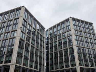 Symmetrical architectural photography of a modern commercial building in London, overcast UK daylight, showcasing steel and concrete junctions.