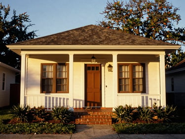 Charming historic cottage exterior in Plant City, sun-drenched neighborhood setting, warm golden-hour light, rich tones, architectural framing, 35mm