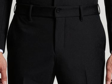 Close-up of modern tailored black trousers on a model, focus on the fabric drape, studio lighting