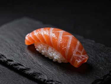 Dramatic close-up of pristine salmon nigiri on a dark slate plate, soft side-lighting highlighting the delicate texture, moody matte black background
